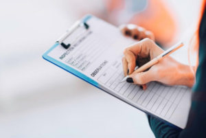 Person writing on a clipboard